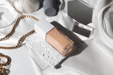 Yaşam tarzına sahip beyaz kumaş tekstil arka planı, kozmetik makyaj şişesi losyon kremi ürünü güzellik moda cilt bakım modeli.