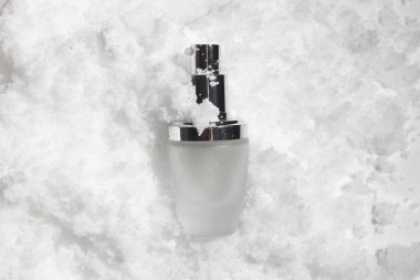 Yaşam tarzına sahip beyaz kar arka planı, kozmetik makyaj şişesi losyon kremi. Güzellik desenli bir krem. Mutlu noel festivali hediyesi olarak.