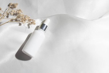 Yaşam tarzına sahip beyaz kumaş tekstil arka planı, kozmetik makyaj şişesi losyon kremi ürünü güzellik moda cilt bakım modeli.