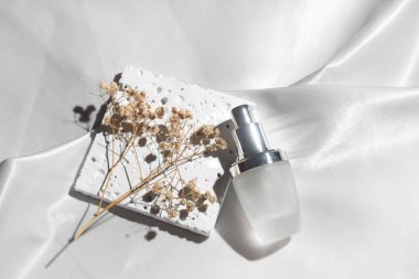 Yaşam tarzına sahip beyaz kumaş tekstil arka planı, kozmetik makyaj şişesi losyon kremi ürünü güzellik moda cilt bakım modeli.