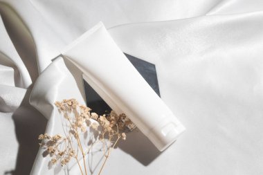 Yaşam tarzına sahip beyaz kumaş tekstil arka planı, kozmetik makyaj şişesi losyon kremi ürünü güzellik moda cilt bakım modeli.