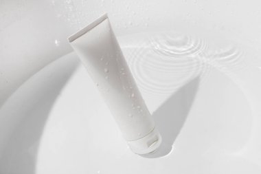 Tıbbi cilt bakımı şişesi kozmetik makyaj tüpü yüz bakımı, yüz temizleyici yüz köpüğü güzellik sağlık hizmetleri ambalajı su sıçraması.