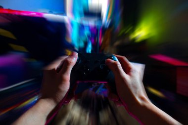 Player online oyun oynuyor oyun kumandası neon ışıklı karanlık siber punk odasında, oyun ve e-spor meydan okuma turnuva canlı ev içinde analog cihazlı flama