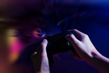 Player online oyun oynuyor oyun kumandası neon ışıklı karanlık siber punk odasında, oyun ve e-spor meydan okuma turnuva canlı ev içinde analog cihazlı flama