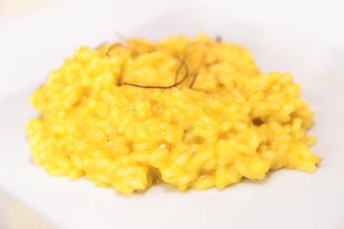 Milano, İtalya 'dan safran iplikli kremalı sarı risotto pilavı. Sığ DOF.