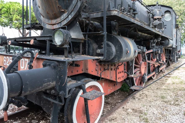 Old abandoned locomotive engine. Vintage and rust steam abandoned. Classic train. Wreck on tracks yesteryear transportation. Bygone era. Italy.