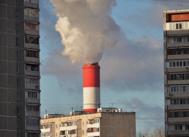 Birleşik ısı ve elektrik santrali (CHP) veya çok katlı konut binalarının arka planına karşı birleşik üretim borusu, Moskova, Rusya