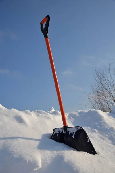在阳光明媚的冬日用铲子扫雪 — 图库照片