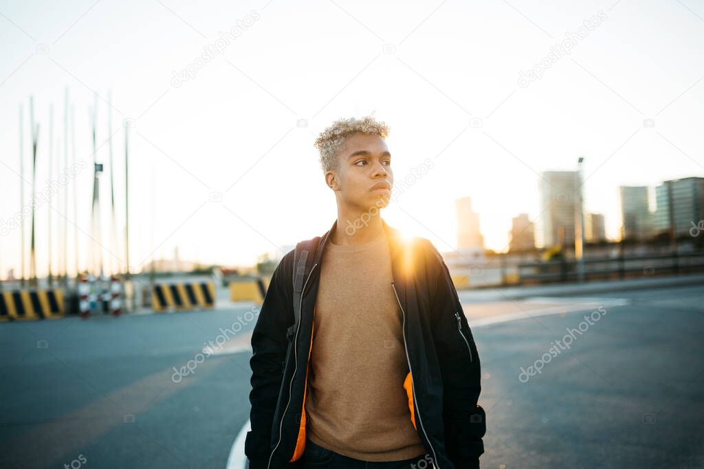 Portrait of a young latin american male walking on a urban scape