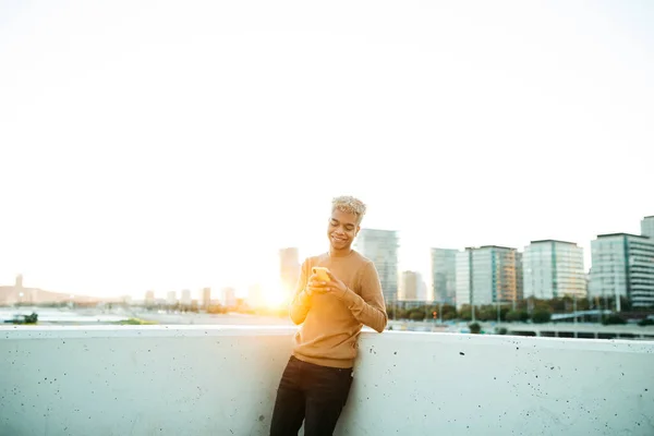 Jovem Latino Americano Masculino Mensagens Texto Sorrindo Smartphone Amarelo Durante — Fotografia de Stock