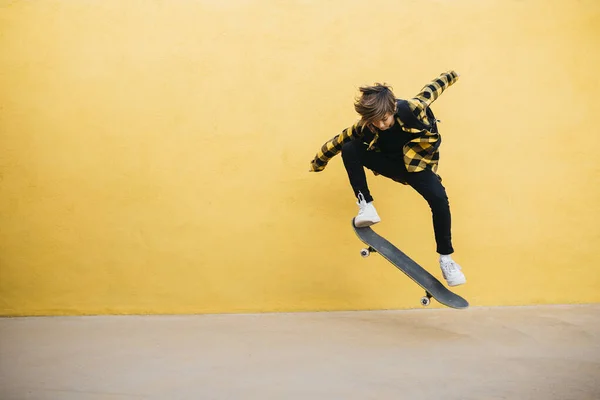 Preteenager Student Boy Jumping Skateboard Front Yellow Background — Fotografia de Stock