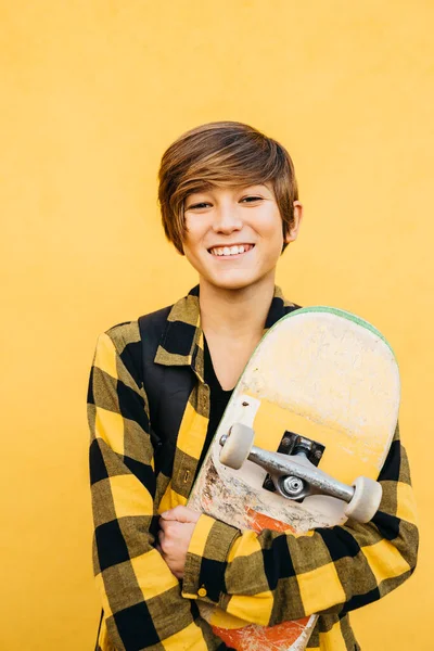 Portrait Smiling Teenager Student Boy Skateboard Front Yellow Background — Fotografia de Stock