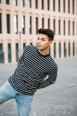 Sokakta yürüyen genç bir erkeğin portresi.