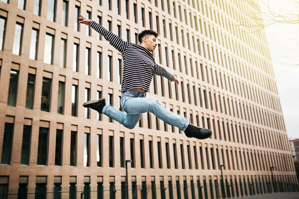 Молодой человек прыгает и танцует на улице