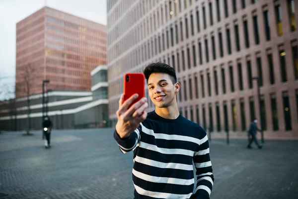 Pemuda Tersenyum Mengambil Selfie Pada Smartphone Merah Jalan — Stok Foto