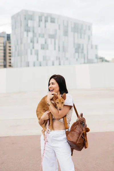 Ung Kvinna Som Bär Hund Sina Armar Gatan — Stockfoto