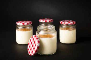 Homemade rice pudding in a glass pot over a black background