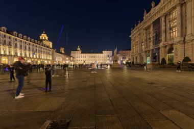Torino, İtalya. 22 Ekim 2021. Gün batımından sonra meydanda birçok insanla birlikte Piazza Castello 'nun genel manzarası. Arka planda Kraliyet Sarayı ve sağda Antik Sanat Müzesi var..