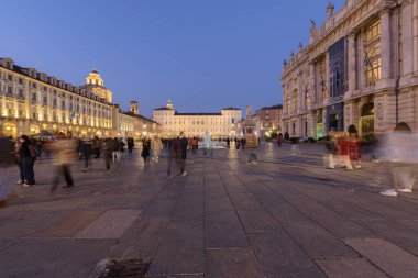 Torino, İtalya. 22 Ekim 2021. Gün batımından sonra meydanda birçok insanla birlikte Piazza Castello 'nun genel manzarası. Arka planda Kraliyet Sarayı ve sağda Antik Sanat Müzesi var..