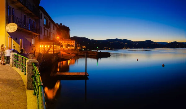 Arona, İtalya. Gün batımından sonra Maggiore Gölü 'ndeki küçük Arona kasabasından panoramik manzara. 10 Haziran 2022.