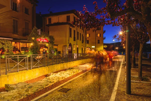 Arona, İtalya. Corso Guglielmo Marconi 'nin gece manzarası. İnsanlar göl kenarında geziniyor. 10 Haziran 2022.