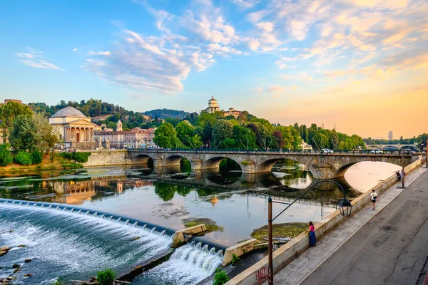 Torino, İtalya. Po Nehri 'nin gün batımında panoramik manzara, Gran Madre Kilisesi, Monte dei Cappuccini Kilisesi ve Vittorio Emanuel I Köprüsü. 13 Temmuz 2022.