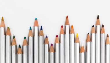 Beyaz arkaplandaki kalemlerin sanatsal şekilleri