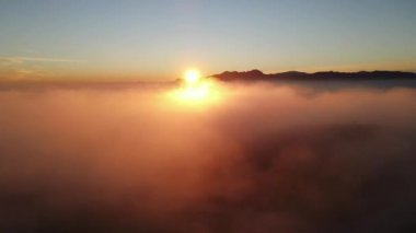 Cumbre del Sol 'da sisli gün batımı. Sis ufku ve kıyı şeridini gizliyor. İspanya, Alicante 'deki Benitachell, Moraira, Calpe ve Javea' dan insansız hava aracı görüntüleri