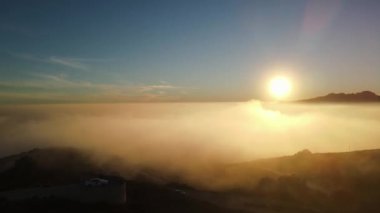 Cumbre del Sol 'da sisli gün batımı. Sis ufku ve kıyı şeridini gizliyor. İspanya, Alicante 'deki Benitachell, Moraira, Calpe ve Javea' dan insansız hava aracı görüntüleri