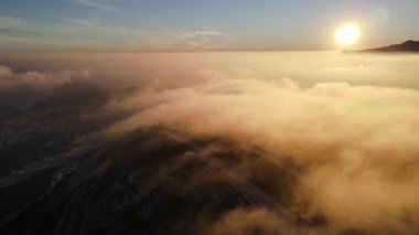 Cumbre del Sol 'da sisli gün batımı. Sis ufku ve kıyı şeridini gizliyor. İspanya, Alicante 'deki Benitachell, Moraira, Calpe ve Javea' dan insansız hava aracı görüntüleri