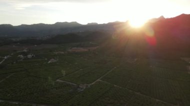 Gandia, Kominitat Valenciana 'daki Marxuquera' dan hava görüntüleri. Güneş dağların arkasında batıyor.
