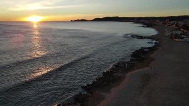 Playa del Montaar, Javea, Alicante, İspanya 'dan hava görüntüleri. Güneş ufukta beliriyor.