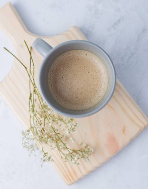 Atölyedeki kesme tahtasının üzerinde bir fincan kahve var. Mutfakta çok az resim var.