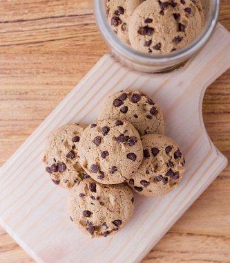Kesme tahtasında biraz kurabiye var. Çikolatalı kurabiyelerin yakın plan fotoğrafı..