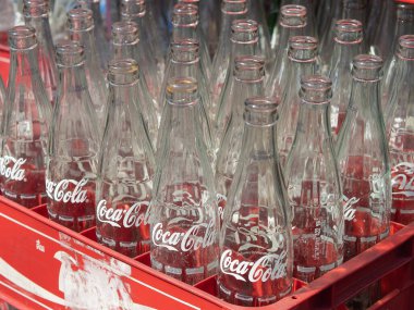 BANGKOK, THAILAND - 24 Mart 2022 'de Bangkok, Tayland' da kırmızı plastik kutuda boş Coca Cola şişeleri. Coca Cola içecekleri The Coca-Cola Company tarafından üretilir ve üretilir.