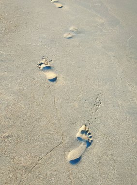 Kumsaldaki insanların ayak izleri var. Metninizi yerleştirmek için boşluk ile.