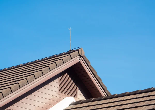 Lightning rod installed on the roof of a residential house to prevent lightning strikes.