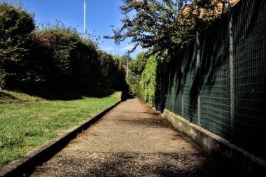 Konut binalarının yanında çit ve çitle çevrili bir geçit.