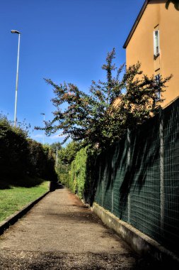 Konut binalarının yanında çit ve çitle çevrili bir geçit.