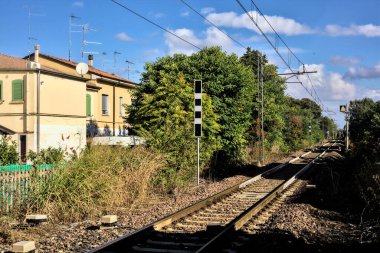 Kırsal kesimdeki yerleşim yerleriyle çevrili demiryolu hattı.