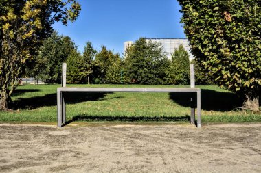 Açık bir günde parkta dinlenmeden bankta oturmak.