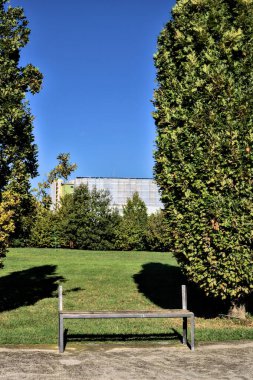 Açık bir günde parkta dinlenmeden bankta oturmak.