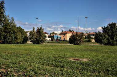 Kırsal kesimde ağaçlar ve uzak binalar var.