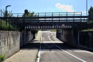 Sonbaharın açık bir gününde İtalya kırsalındaki bir yolun boş alt geçidi.