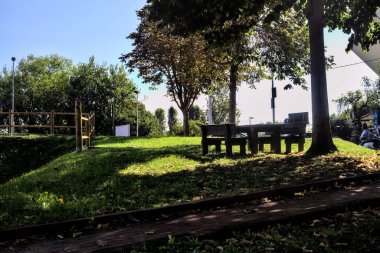 Yolun yanındaki ağaçların gölgesinde piknik masası