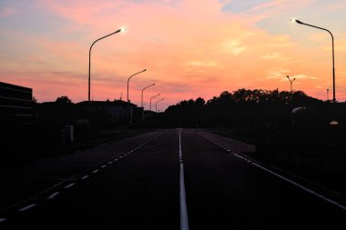 Alacakaranlıkta evleri ve ağaçları olan bir yerleşim bölgesinde.