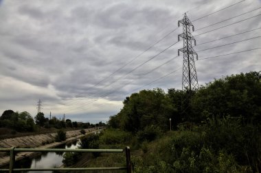 Sonbaharda bulutlu bir günde korulukla çevrili saptırıcı kanal.