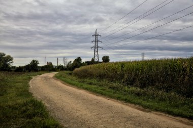 İtalya kırsalındaki tarlaların yanındaki çakıl yolu Sonbaharda bulutlu bir günde