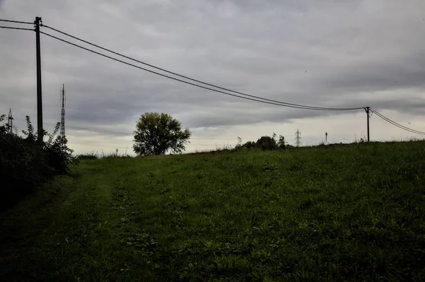 Fűves Ösvény Lejtőn Egy Mezőn Fej Felett Kábelek Egy Felhős — Stock Fotó