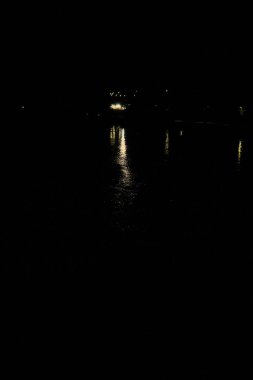 Geceleyin göl kenarındaki yoldan geçen arabalar görülebiliyor.